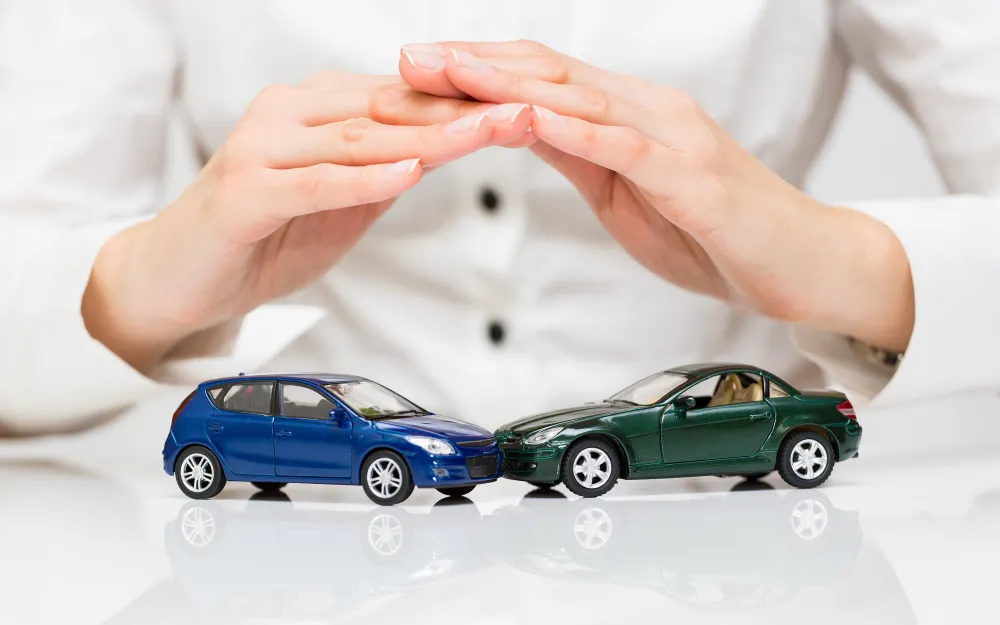Mano protegiendo carros de juguete